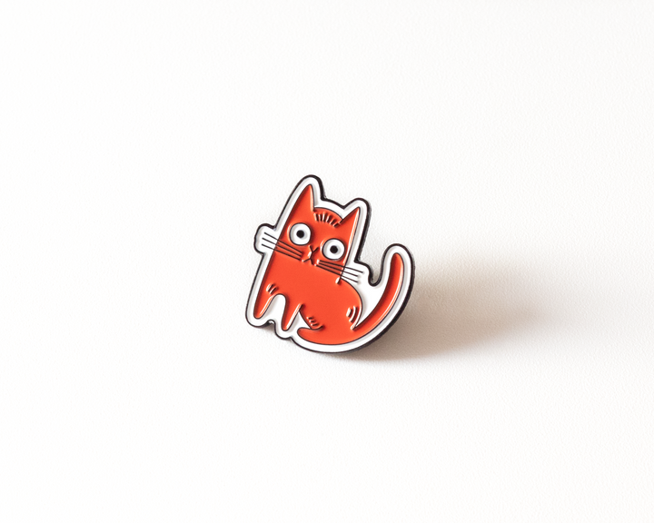 angled view of red cat enamel pin